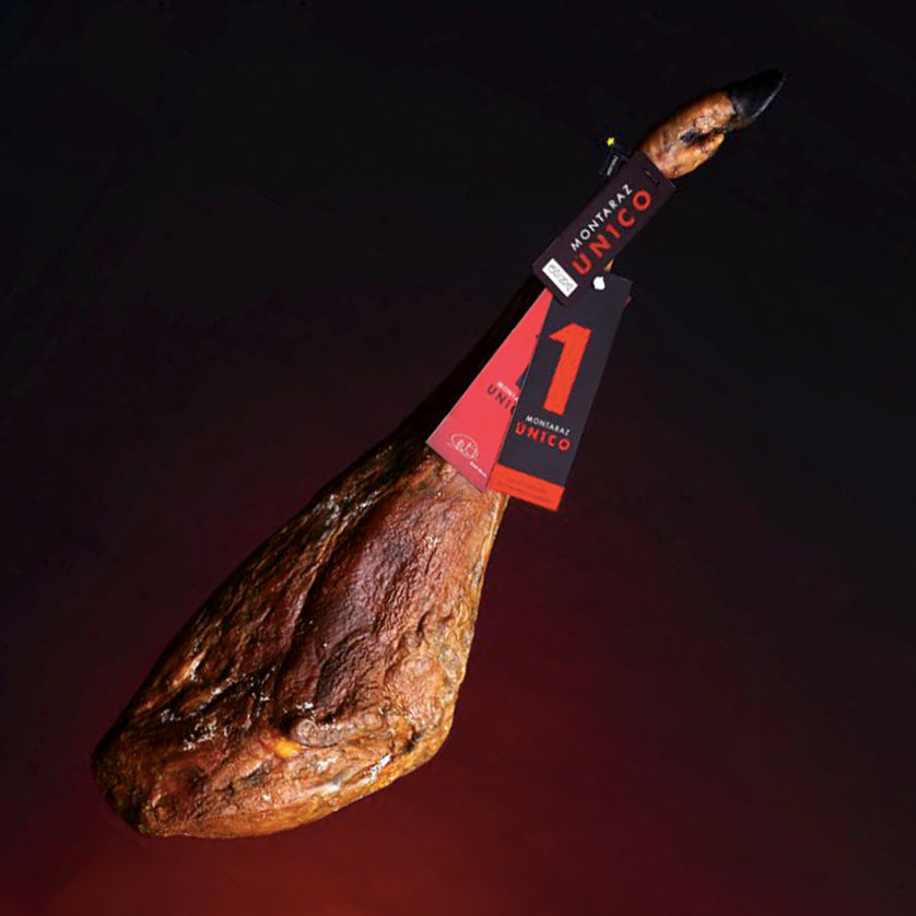 Montaraz UN1CO Bellota Jamon, bone-in, showcasing its premium quality with a black label and rich marbling.