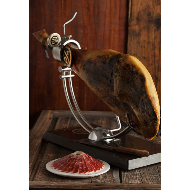  A beautifully plated serving of Cinco Jotas 5J Iberico Jamon, with ham holder in background.